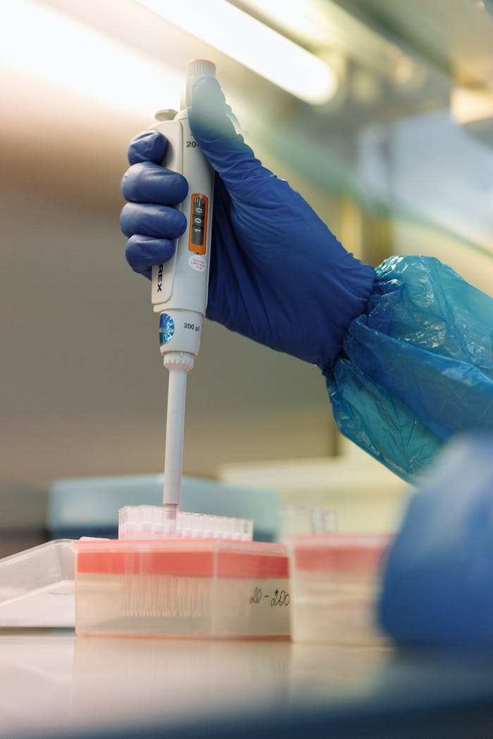 Close-up of a scientist using a pipette in a laboratory, focusing on precision and safety.